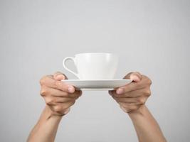 Hands giving white coffee cup isolated photo