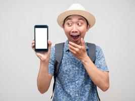 Traveler asian man show mobile phone and feels excited about booking at holiday isolated photo