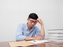 Asian businessman wear glasses sit at working table feels tried photo