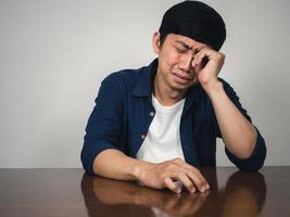 Asian man sit at table feels depressed and sadness and crying about life photo