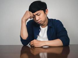 Asian man sit at table feels depressed and sadness about life photo