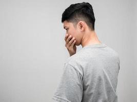 Asian man grey shirt turn back worried emotion isolated photo
