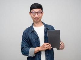 Positive man wear glasses jeans shirt smile show the diary in his hand isolated photo
