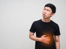 Asian man hold his belly feels stomach ache isolated photo