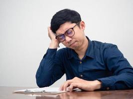 Young man wear glasses feels headache about testing on table photo