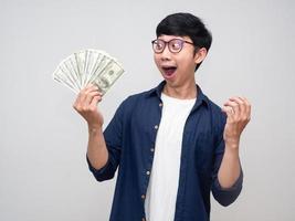 Positive man feels shocked about earn money in his hand isolated photo