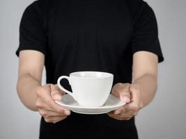 Close up man giving coffee white cup in his hand studio shot photo