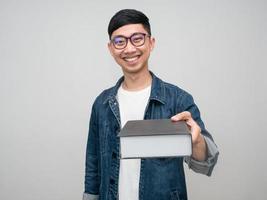 Positive man wear glasses jeans shirt happy smile giving the book at you photo