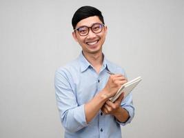 Positive businessman wear glasses hold diary with gentle smile gesture shy isolated photo