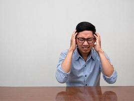 Asian businessman feels headache sit at table photo