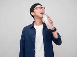 Young asian man wear glasses drinking water isolated photo