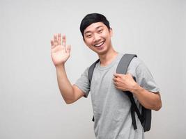 School boy with backpack smile and show hand hello isolated photo