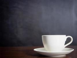 Close up white coffee cup on wood table dark background photo