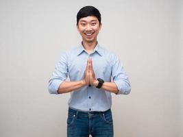 Young thai man gesture respect hand with happy smile isolated photo