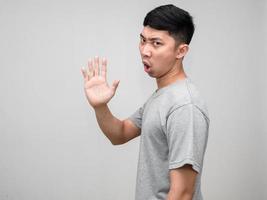 Asian man grey shirt feels angry turn around say no show hand hold isolated photo