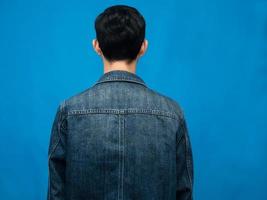 Back side of man jeans shirt blue background photo