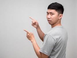 Asian man grey shirt confused turn around gesture point finger isolated photo