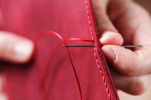 Conceptual profession of a Tanner. The woman's hands closed around the needle and thread. photo