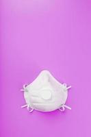 Protective Mask on a pink background. Isolate, top view. photo