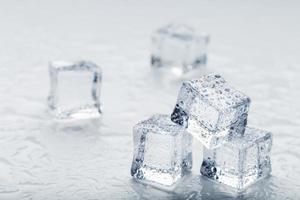 Ice cubes in the form of a pyramid with water drops close - up in macro on a white background. photo