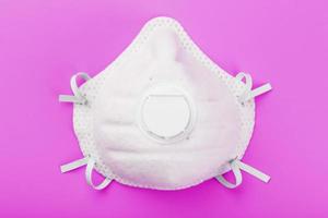 Protective Mask on a pink background. Isolate, top view. photo