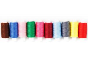 Colorful cotton craft sewing threads multicolored in a row isolated on a white background. photo