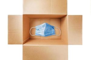 máscara médica en una caja de cartón para protegerse contra el virus. foto