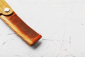 Folding wooden comb on a gray background. photo
