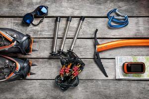 Top view of tourist equipment for a mountain trip on a rustic light wooden floor. photo