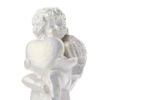 estatua de querubín aislado sobre fondo blanco. ángel sostiene el corazón. amar