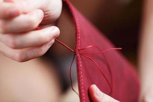 Conceptual profession of a Tanner. The woman's hands closed around the needle and thread. photo