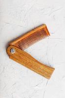 Wooden Sandalwood comb folding on a white textured background. photo