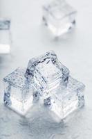 Ice cubes in the form of a pyramid with water drops close - up in macro on a white background. photo