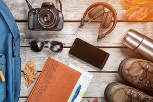 Set of things and tourist equipment for travel and adventure on a gray wooden background. Top view set photo