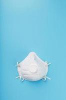 White face Mask on a blue background, protecting the respiratory system. Isolate photo