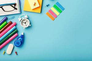 Office supplies lie on a blue background. To study in school. Rainbow color. photo