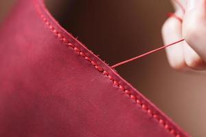 Conceptual profession of a Tanner. The woman's hands closed around the needle and thread. photo