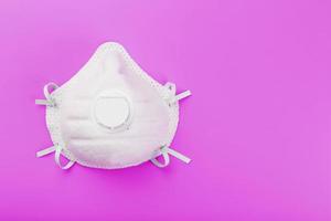 Protective Mask on a pink background. Isolate, top view. photo