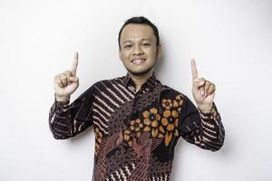 Excited Indonesian man wearing a batik shirt giving number 12345 by hand gesture photo