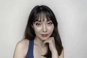 una cara alegre de belleza de una joven modelo asiática con una camiseta verde azulado. maquillaje cuidado de la piel belleza tratamiento facial, spa, concepto de salud femenina. foto