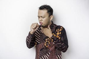 Sick Asian man wearing batik shirt is flu and cough. Illness, influenza, pain concept. Healthcare and Corona Concepts.