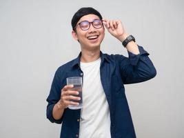 Positive asian man feels fresh with drinking water in hand isolated photo