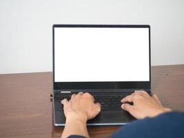 Man hands using keyboard of laptop mockup white screen on the table photo