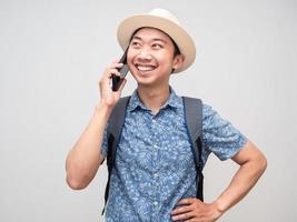 viajero hombre camisa azul alegre hablando teléfono móvil con vacaciones aislado foto