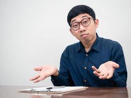 el hombre de negocios asiático siente dudas y está confundido sobre el trabajo en la mesa de trabajo foto
