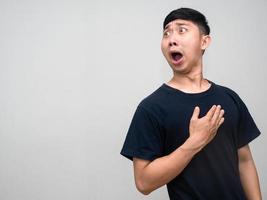Asian man black shirt shocoked face turn around to looking at copy space photo
