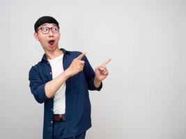 Cheerful asian man wear glasses turn around to gesture point finger isolated