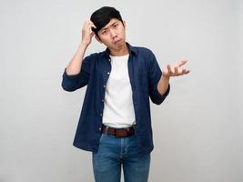 Asian man standing gesture scratch head feels doubt and confused isolated photo