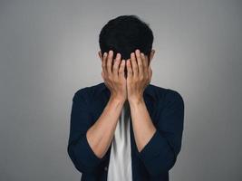 Depressed asian man crying about his life isolated photo