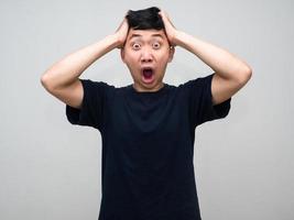 Young asian man feels shocked hold his head isolated photo